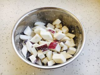 3、豌豆烧茄子,把茄子切成菱形状的块,块的大小随意,看个人喜好。撒入薄薄的一层淀粉,让淀粉裹上茄子。