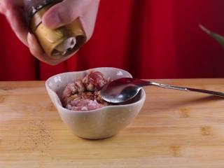 2、蒸豆腐的新吃法,口感嫩滑好吃爽口,接着我们开始腌制肉馅,加入一小勺的生抽、适量的黑胡椒粉、一小勺盐。