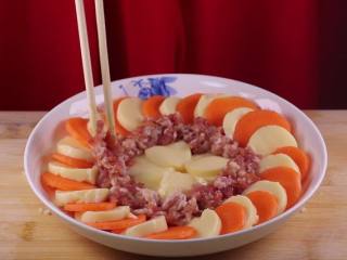 9、蒸豆腐的新吃法,口感嫩滑好吃爽口,剩下的玉子豆腐码在盘子中间,将肉馅放入豆腐间的缝隙中,绕一圈摆放。