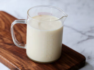 9、茶冻撞珍珠奶茶,将白糖、纯牛奶、淡奶、纯净水加入杯中,搅拌至白糖融化