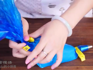 8、玫瑰马卡龙,将裱花嘴装到裱花袋，面糊倒入裱花袋，上端用夹子固定