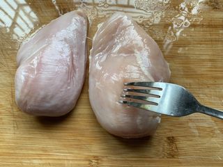 2、香煎鸡胸肉,用叉子在解冻好的鸡胸肉上多扎几次