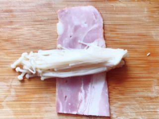 5、培根卷金针菇,取一小撮金针菇放在培根上