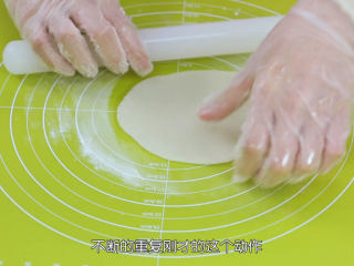 7、雪媚娘大福,在硅胶垫和面团都抹上一点手粉，右手把擀面杖往身体这边滚到底，左手一边轻轻的拉扯面团，尽量让面团伸展开，然后把皮逆时针转动一下，不断重复刚才的这个动作，面皮就能慢慢的擀开了，擀到能看见一点下面的硅胶垫图案就可以了，不要擀得太薄，否则待会包的时候，皮太薄就会很软，塌下来，而且也会很容弄破这个表皮