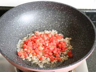 6、番茄肉酱拌面,再倒入番茄丁翻炒至出汁；