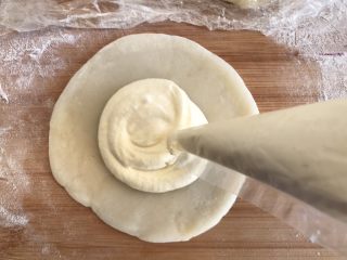 14、芒果雪媚娘,取一个糯米团擀成饼,中间挤上奶油