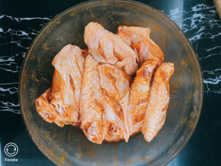 3、奥尔良烤鸡翅,倒入奥尔良烤翅腌料、料酒拌匀并稍作按摩。