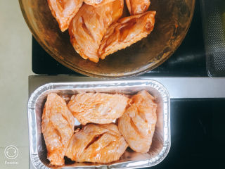 5、奥尔良烤鸡翅,将鸡翅放入容器中，放上一根迷迭香。