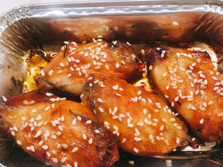 7、奥尔良烤鸡翅,打开烤箱，将鸡翅翻面撒上白芝麻，继续放入烤箱烤10分钟。