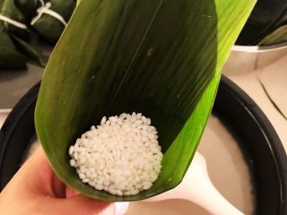 13、蜜豆糯米粽子,取半勺浸泡好的糯米放入粽子卷里
