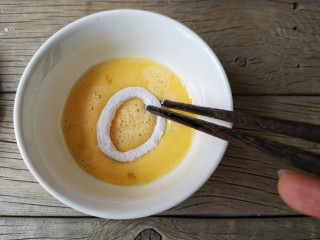 8、香酥鱿鱼圈,再放蛋液里，均匀的沾上蛋液。