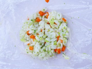 9、西兰花肉松芝士饭团,取一块保鲜膜，将饭团放入保鲜膜中。