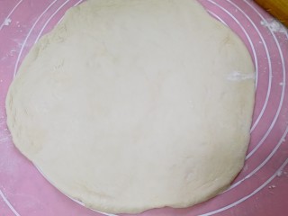 5、榴莲披萨,把面团取出，按压排气后，用擀面杖擀成比披萨盘略大的面饼。