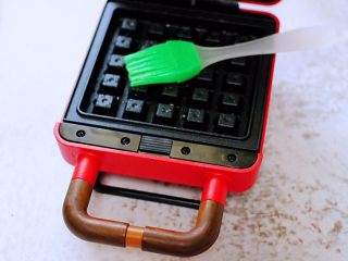 9、蜜豆华夫饼,华夫饼机器提前预热后,用硅胶刷子在机器上刷少许油。