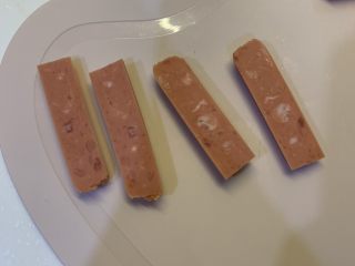 1、微波炉鸡蛋火腿三明治,火腿对半切段，再在每一段里对半再切开