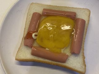4、微波炉鸡蛋火腿三明治,把鸡蛋打进去，用叉子戳破蛋黄