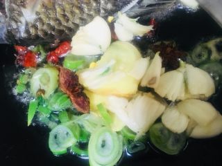 6、红烧鲫鱼,把鱼推到一边，另外一边放入葱姜蒜小米椒花椒八角一起爆香