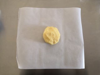 4、苹果奶酥小挞,混合成面团后取一张油纸将面团放在油纸上。