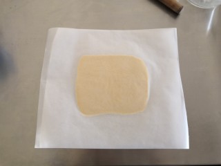 5、苹果奶酥小挞,在面团上在盖一张油纸，用擀面杖将面团擀成0.6㎝厚度，放入冰箱冷冻半小时。