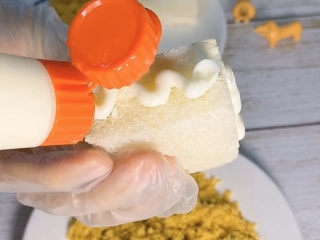 9、肉松仙贝,先给四个边封面，也是挤上沙拉酱，用勺子抹平