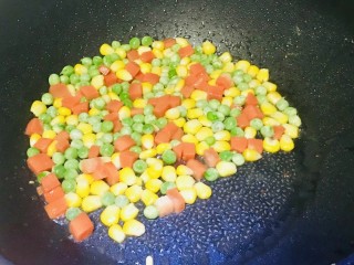 14、菠萝虾仁炒饭,锅内剩余的油加入玉米粒，胡萝卜丁，青豆翻炒