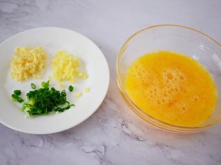 3、虾仁炒鸡蛋,鸡蛋加入盐搅打均匀备用，蒜切末，姜切末，葱切葱花