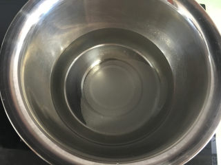 4、芒果水晶果冻,将纯净水和白糖放入盆中，放在燃气灶上小火加热。