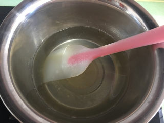 5、芒果水晶果冻,一边加热一边搅拌，搅拌至糖完全溶解后关火，趁水热的时候倒入溶解好的吉利丁溶液。