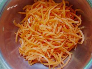 3、粉蒸胡萝卜丝,找一纱布包住胡萝卜，用力把水挤出来。用一点点食用油搅拌一下，防止蒸的时候比较干