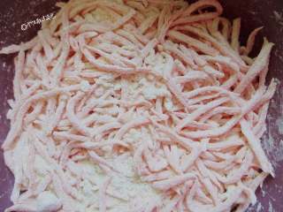 5、粉蒸胡萝卜丝,让每根胡萝卜丝都被包裹住。拌好后，再抓匀。