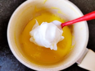 7、草莓抱抱卷,取少许蛋白霜入蛋黄糊中，翻拌均匀。