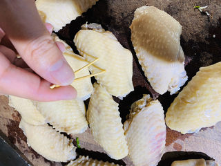 5、炸鸡中翅,洗干净，沥干水分，用牙签将鸡翅两面各扎十几个小洞。