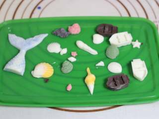 5、海底世界果冻,白巧克力隔水融化，做出各种小贝壳！贝壳要大小不一穿插着！我还比较有闲心的用黑巧克力做了一个有着铁链的漂浮球出来