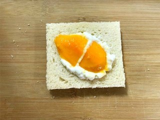 4、芒果酸奶土司,取一片吐司，先放上2勺酸奶，再放上芒果。芒果可以换成自己喜欢的水果.