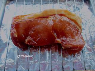 4、叉烧肉,把腌制好的肉放在烤盘上,刷上蜂蜜和油