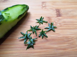 3、草莓饭团,用黄瓜皮切出草莓帝的形状备用。