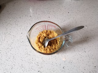 3、重芝士蛋糕,将饼干碎倒入融化的黄油里搅拌均匀。