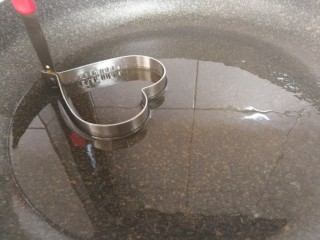 16、青椒蛋饼,将模具放入到热油中，模具边上站上油。