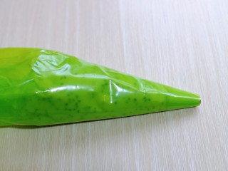 10、黑芝麻麻薯面包,将拌好的麻薯糊放入裱花袋,先装上圆的裱花嘴,不装也可以。(裱花袋最好使用橡胶的,面糊比较干,挤的时候需要用力,不然裱花袋容易破)
