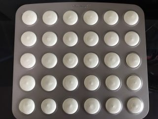 9、意式抹茶马卡龙,将面糊倒入套了中号圆形裱花嘴的裱花袋中，均匀的挤到马卡龙烤盘上。也可以用马卡龙硅胶烤垫或者高温油布，注意间距。
