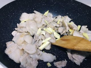 6、下饭菜之青椒炒肉片,将大蒜洗净拍松切小块放入锅中