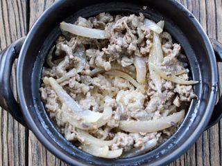13、肥牛窝蛋砂锅,再放入肥牛洋葱,再把汤汁倒在米饭上,中间留一个蛋黄的空位
