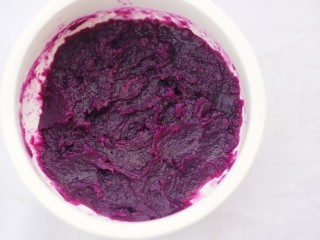3、香甜软糯的奶香紫薯芝麻方饼,压成泥。