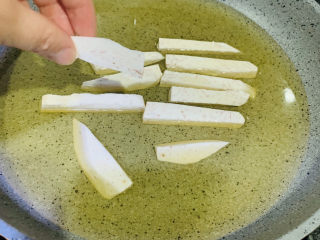 6、翻砂芋头,冷锅冷油放入芋头;