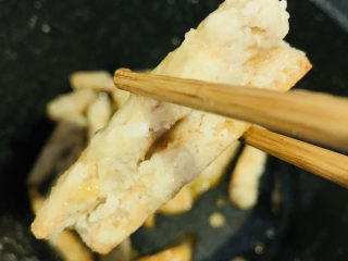 15、翻砂芋头,将芋头翻裹均匀,出现翻砂状,就可以一根根夹起来,盛入碗内;