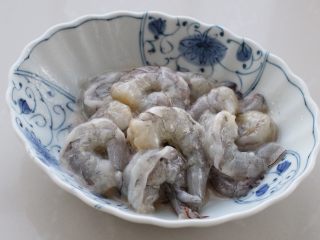 3、虾仁炒鸡蛋,将剥好的虾仁放入碗中,加少许盐、一汤匙玉米淀粉和一汤匙食用油,抓拌均匀后覆盖保鲜膜腌制30分钟,如果是夏季比较热的天气就放进冰箱冷藏室