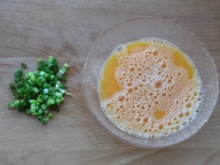 4、虾仁炒鸡蛋,鸡蛋磕入碗中加适量的盐、几滴料酒和两汤匙温水,搅打均匀,小葱洗净切葱花备用