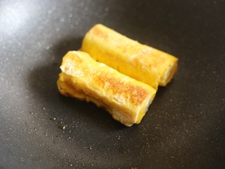 12、无敌简单的香蕉土司卷,将卷好的香蕉卷放入锅中，小火煎至两面金黄。