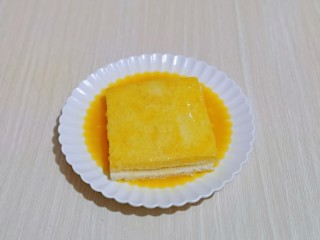 8、快手早餐～香蕉酸奶三明治,放入打散的蛋液盘中，将吐司的两面及四边均匀裹上蛋液。