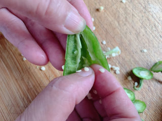 3、青椒炒香肠,对半切开去籽（因为怕太辣）。